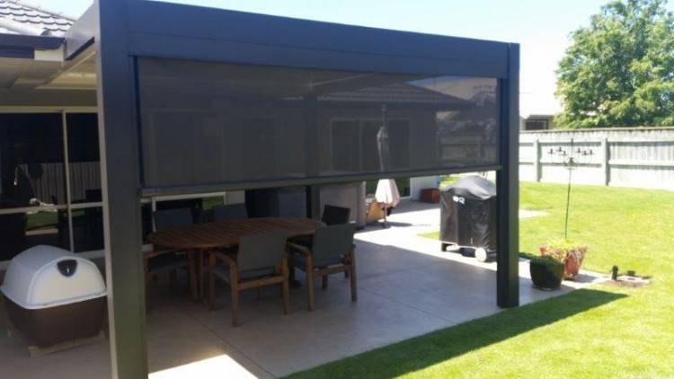 The partially covered outdoor living space boasts a open fire/barbeque